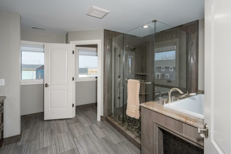 An updated master bathroom showcasing modern fixtures and tile work.